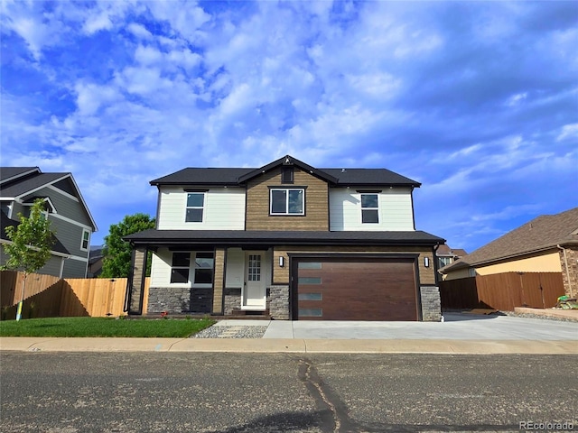 5550 Wetlands Dr, Longmont, CO 80504 - view of front of property with concrete driveway, an attached garage, stone siding, and covered porch