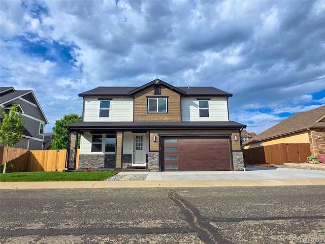 5550 Wetlands Dr, Longmont, CO 80504 - view of front facade with stone siding, covered porch, a garage, and concrete driveway