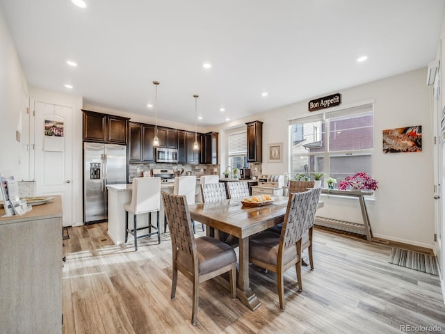 dining area featuring baseboards, light wood-type flooring, and recessed lighting