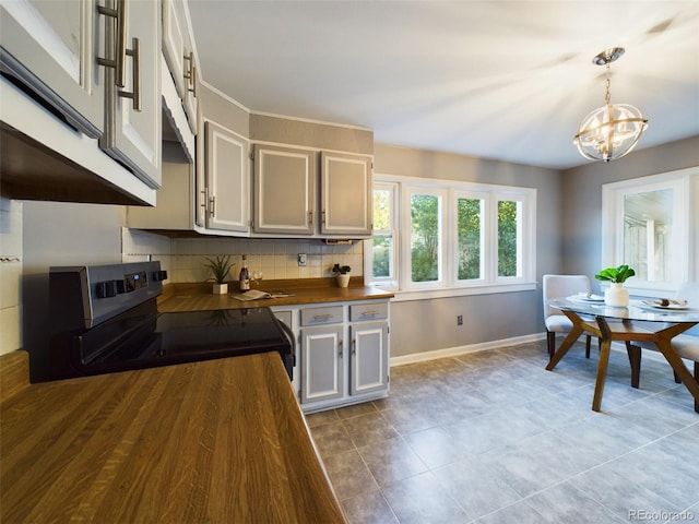 kitchen with hanging light fixtures, white cabinetry, stainless steel range with electric cooktop, butcher block counters, and decorative backsplash