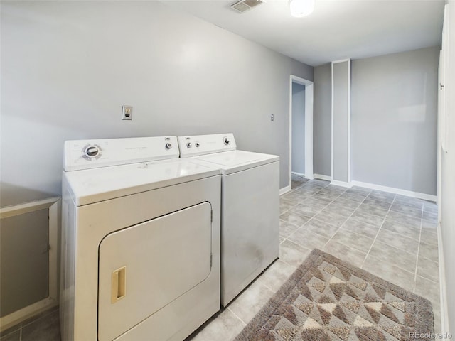 washroom with light tile patterned floors and washer and dryer