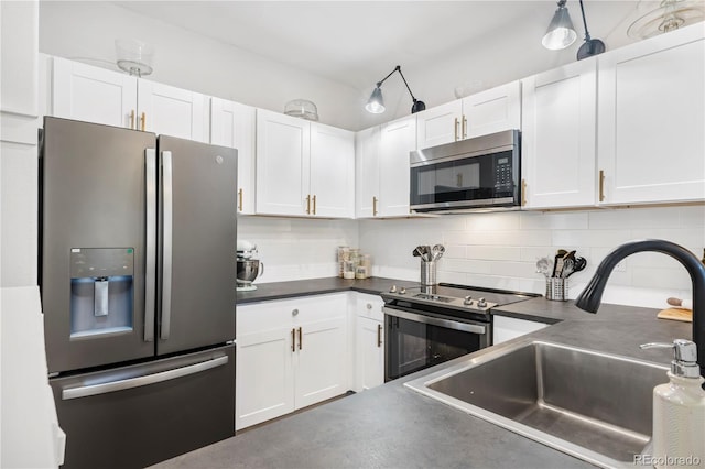 4085 S Crystal Cir Unit 101, Aurora, CO 80014 - kitchen featuring appliances with stainless steel finishes, dark countertops, and white cabinets