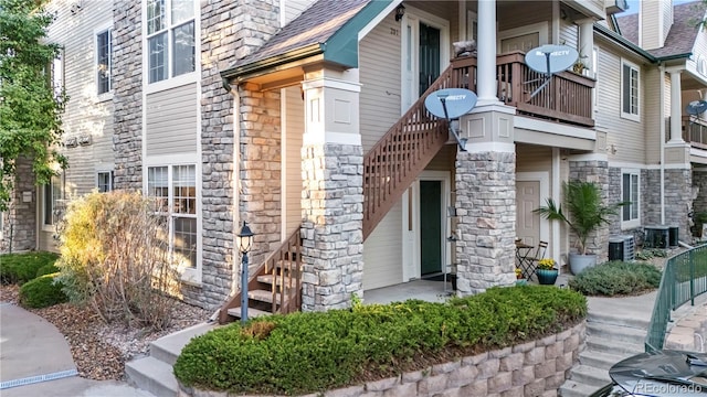 4085 S Crystal Cir Unit 101, Aurora, CO 80014 - view of side of home featuring stone siding, a balcony, stairs, and a shingled roof