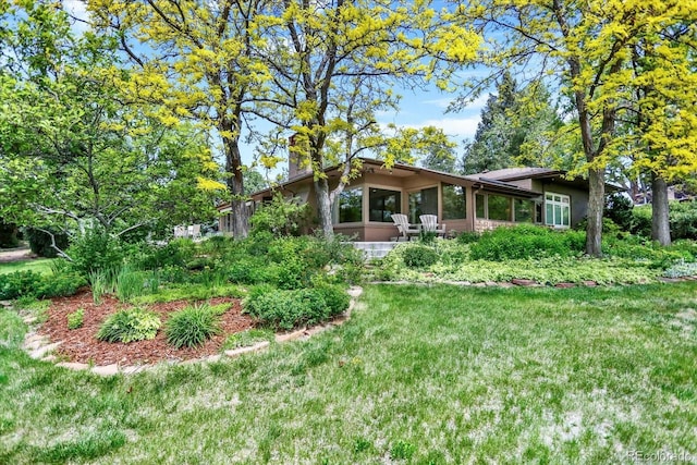 4790 W Lakeridge Rd, Denver, CO 80219 - rear view of house with a sunroom, a chimney, and a lawn