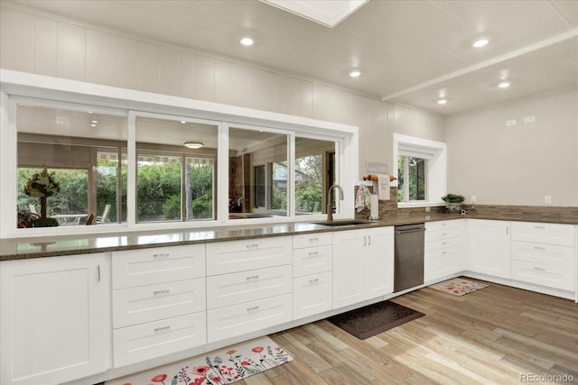 4790 W Lakeridge Rd, Denver, CO 80219 - kitchen with a sink, dishwasher, light wood-style floors, white cabinets, and dark stone counters
