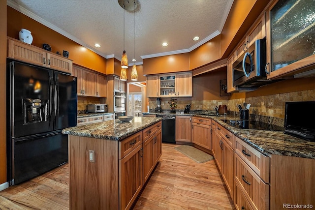 kitchen with light hardwood / wood-style flooring, a center island, pendant lighting, and black appliances