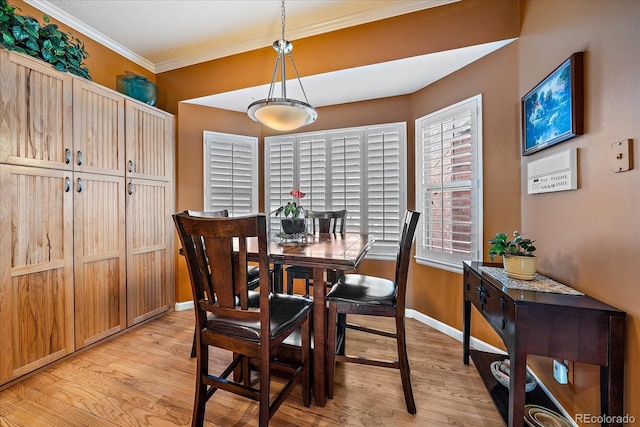 dining area featuring crown molding and light wood-type flooring