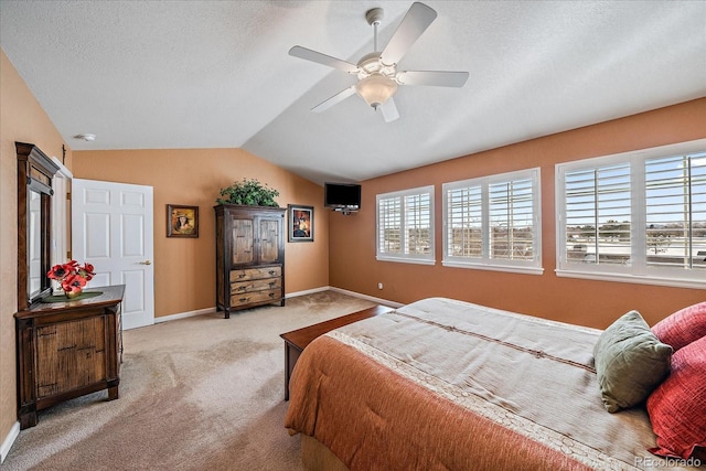 carpeted bedroom featuring ceiling fan, lofted ceiling, and a textured ceiling