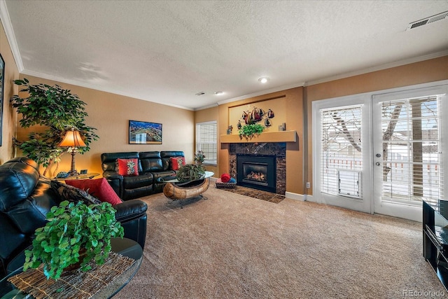 living room featuring crown molding, a fireplace, a textured ceiling, and carpet