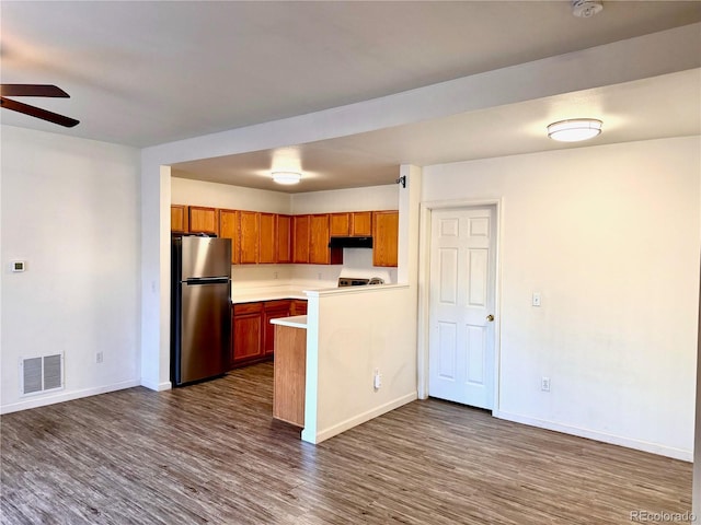 kitchen featuring ceiling fan, stainless steel fridge, and dark hardwood / wood-style flooring