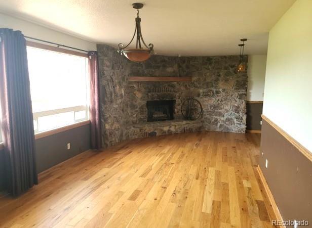 unfurnished living room with a fireplace and light hardwood / wood-style floors