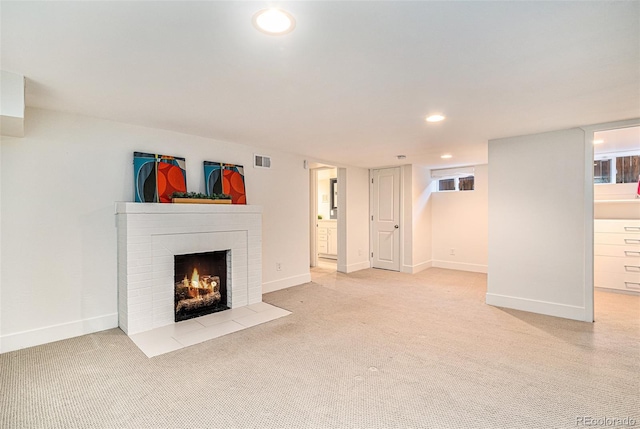 unfurnished living room with a brick fireplace and light carpet