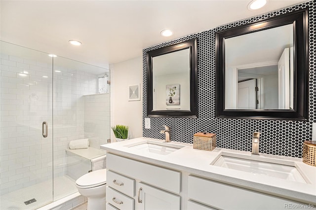 bathroom featuring toilet, a shower with door, and vanity