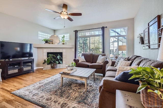 11638 Xavier Way, Westminster, CO 80031 - living room featuring wood finished floors, ceiling fan, a tiled fireplace, and a textured wall