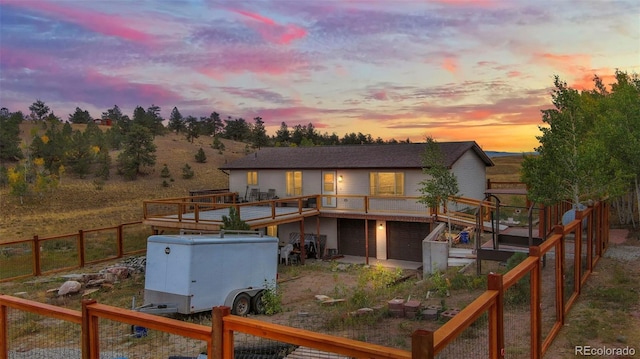 back house at dusk with a wooden deck