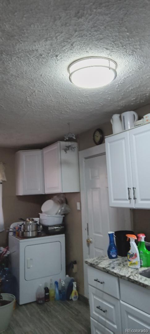 clothes washing area with hardwood / wood-style floors, a textured ceiling, and washer / clothes dryer