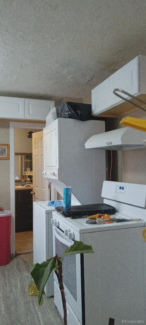 details with gas range gas stove, hardwood / wood-style floors, exhaust hood, and a textured ceiling