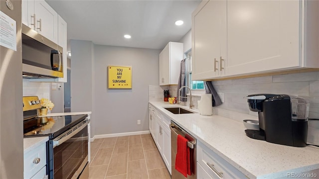 7609 Sherman Pl, Denver, CO 80221 - kitchen with white cabinetry, stainless steel appliances, sink, and backsplash