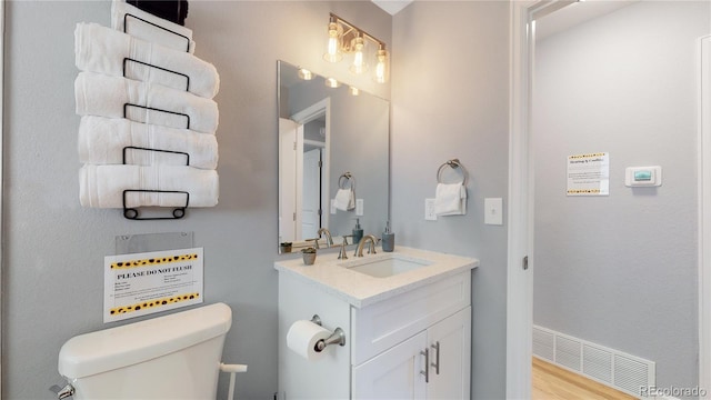 7609 Sherman Pl, Denver, CO 80221 - bathroom featuring vanity, toilet, and wood-type flooring