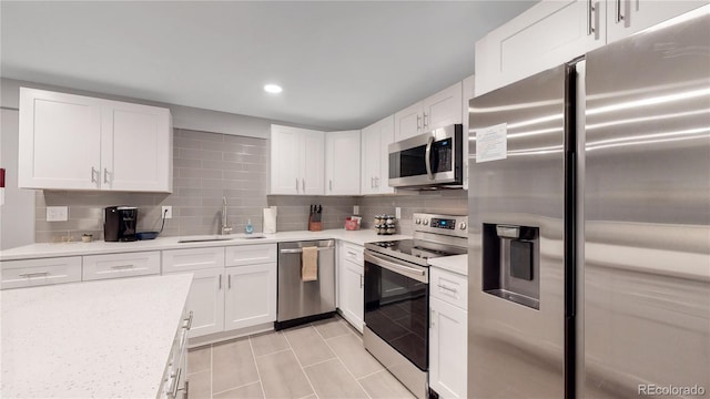7609 Sherman Pl, Denver, CO 80221 - kitchen with tasteful backsplash, stainless steel appliances, sink, and white cabinets