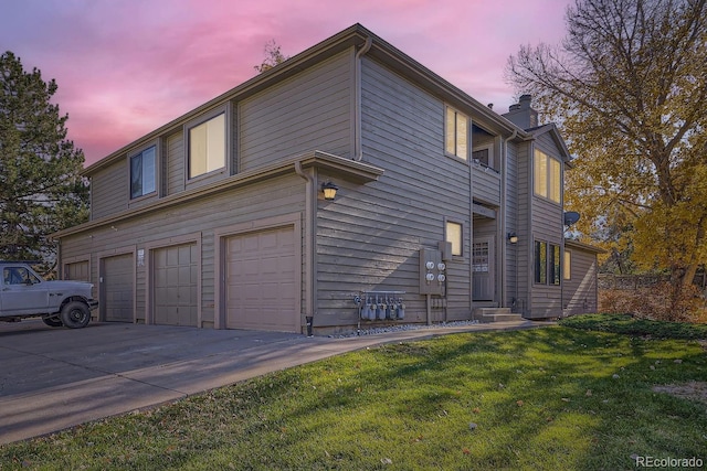 property exterior at dusk featuring a lawn and a garage