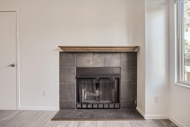 details with a tile fireplace and hardwood / wood-style flooring