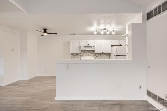 kitchen with white appliances, white cabinetry, backsplash, kitchen peninsula, and ceiling fan