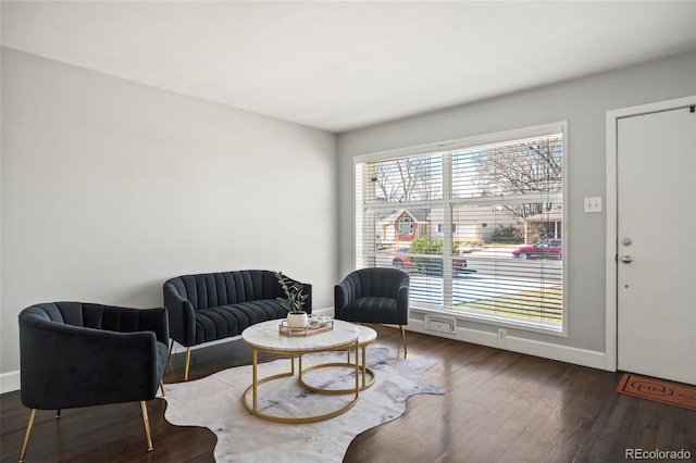 living area with baseboards and wood finished floors