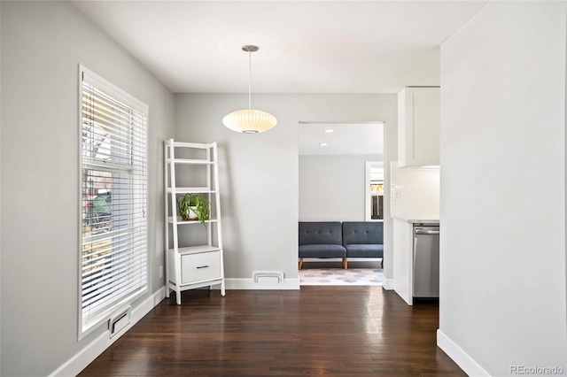 unfurnished dining area with dark wood finished floors, visible vents, and baseboards