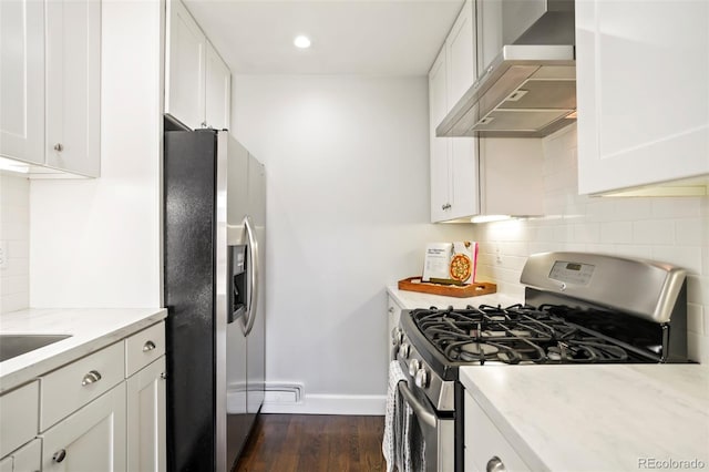 kitchen featuring backsplash, wall chimney range hood, dark wood finished floors, stainless steel appliances, and white cabinetry