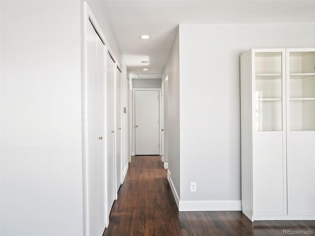 hallway featuring recessed lighting, baseboards, and dark wood-style flooring