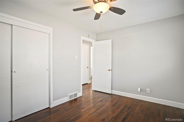 unfurnished bedroom with visible vents, dark wood-type flooring, a ceiling fan, a closet, and baseboards