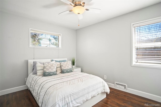 bedroom featuring a ceiling fan, wood finished floors, visible vents, and baseboards