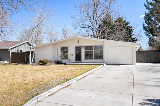 mid-century home with a front lawn, fence, a garage, and driveway