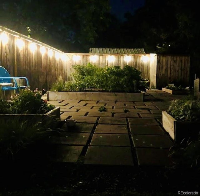 patio at twilight featuring fence