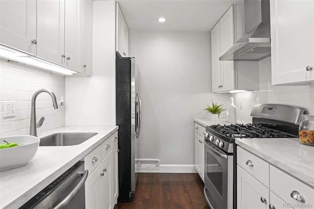 1360 S Hudson St, Denver, CO 80222 - kitchen featuring stainless steel appliances, wall chimney range hood, tasteful backsplash, white cabinets, and recessed lighting