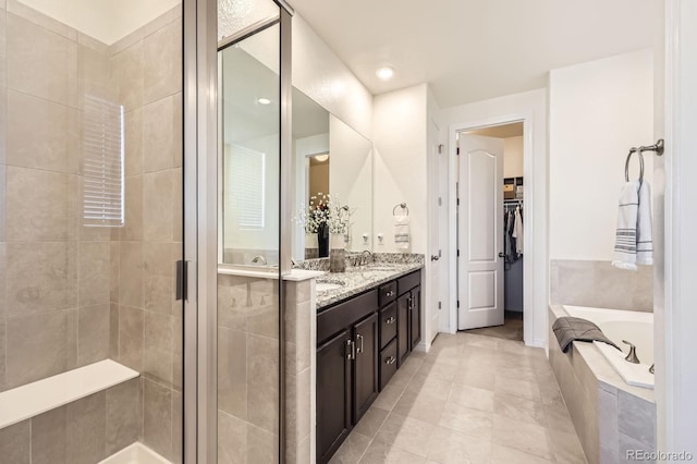 full bathroom with a bath, a stall shower, and vanity