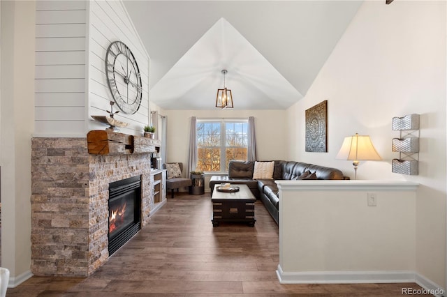 living room with dark hardwood / wood-style floors, vaulted ceiling, and a fireplace