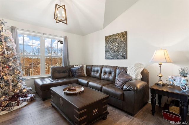 living room with an inviting chandelier, vaulted ceiling, and dark hardwood / wood-style flooring