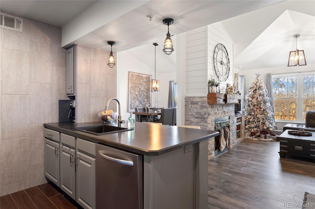 kitchen with hanging light fixtures, lofted ceiling, dark hardwood / wood-style flooring, a fireplace, and sink