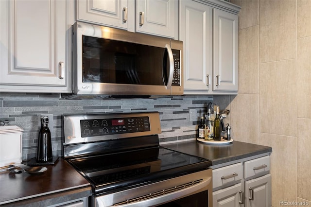 kitchen with stainless steel appliances, white cabinetry, and tasteful backsplash