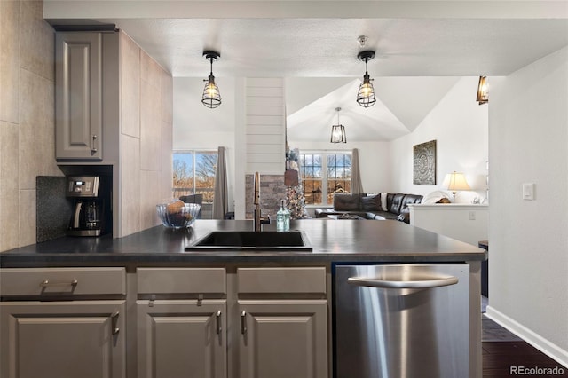 kitchen featuring sink, hanging light fixtures, stainless steel dishwasher, and dark wood-type flooring