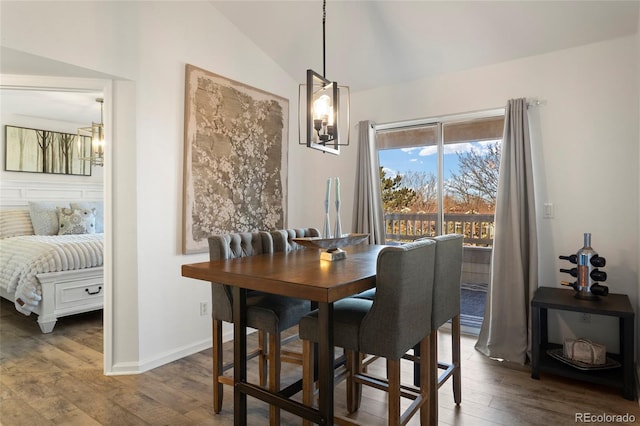 dining room with an inviting chandelier, lofted ceiling, and wood-type flooring