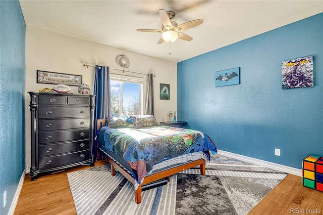 bedroom with a ceiling fan, light wood-style floors, baseboards, and a textured wall