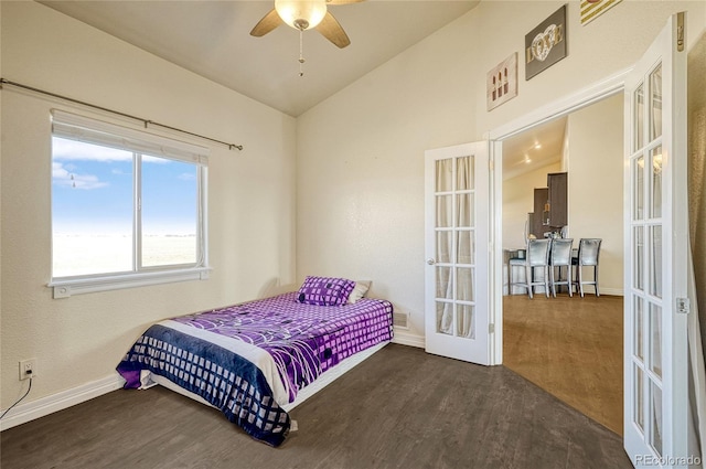 bedroom featuring lofted ceiling, wood finished floors, french doors, and baseboards