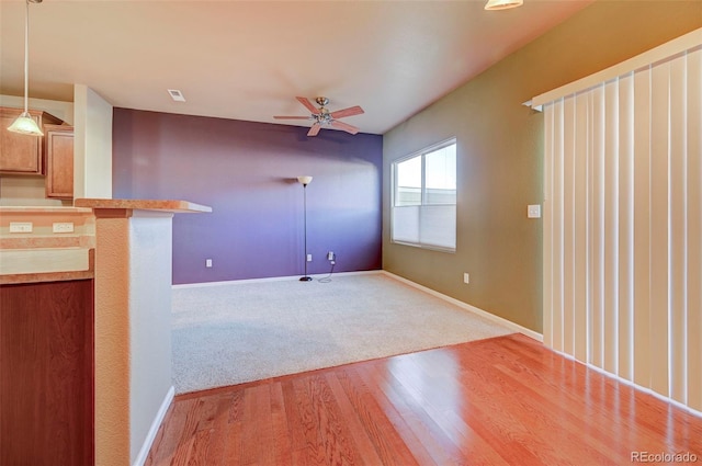 unfurnished living room with ceiling fan and light hardwood / wood-style flooring