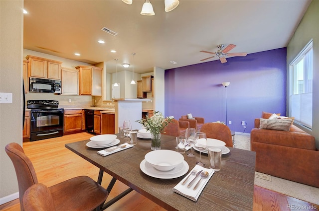 dining space featuring ceiling fan, sink, and light hardwood / wood-style flooring