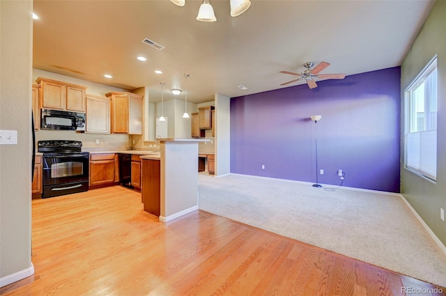 kitchen with ceiling fan, black appliances, decorative light fixtures, kitchen peninsula, and light wood-type flooring