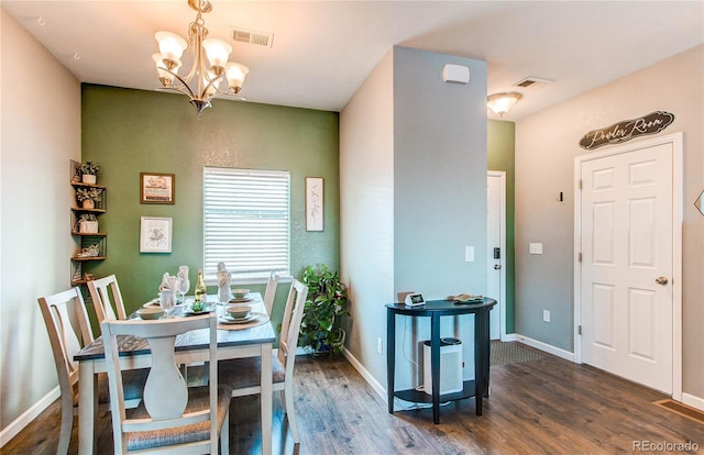 dining space featuring dark hardwood / wood-style flooring and a chandelier