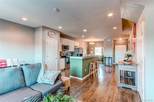 living room featuring hardwood / wood-style flooring, sink, and a chandelier